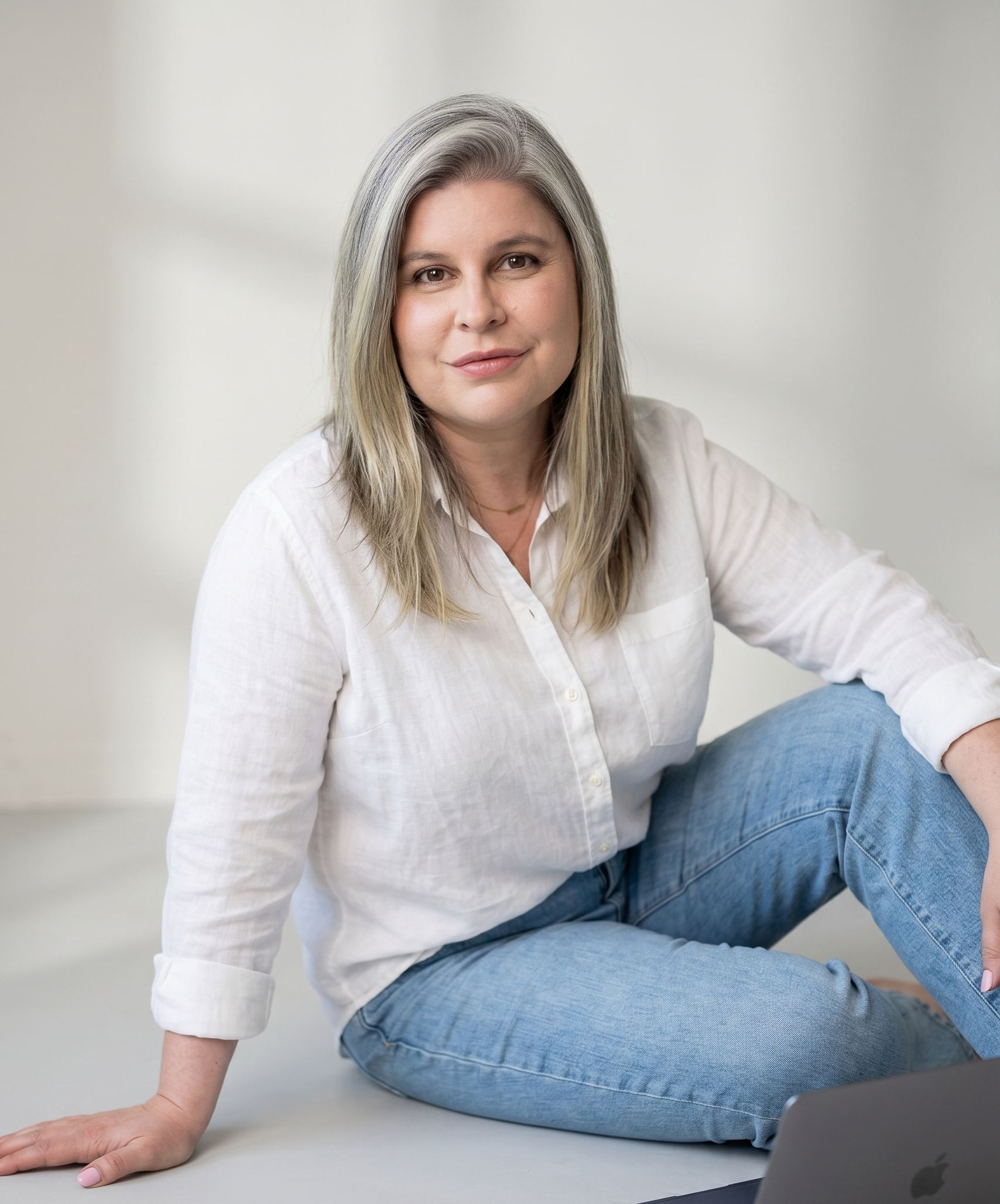 Aline Rivieri wearing white and seated for a portrait